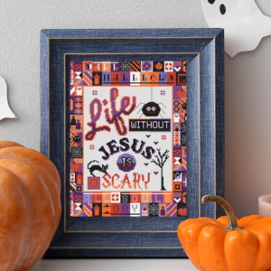 Catholic Halloween Cross Stitch Pattern framed surrounded b y typical Halloween Decor